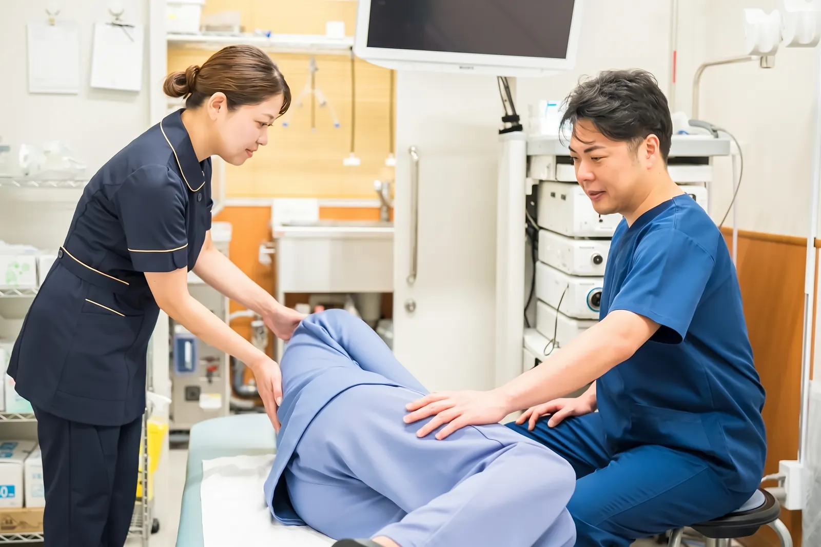 検査中の受診者に付き添う医師と看護師